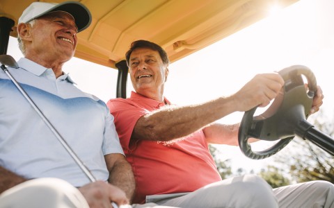 两个人坐在高尔夫球车上