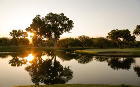 大池塘映衬着高尔夫球场和夕阳