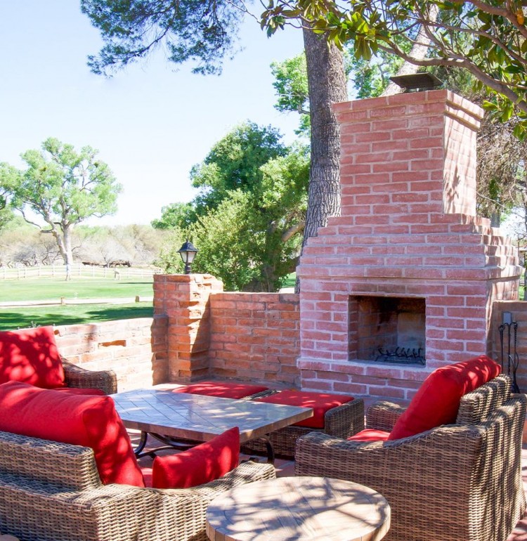 Outdoor patio with grey chairs and a fireplace
