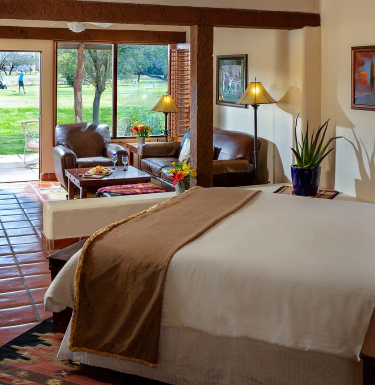 bed in suite with fireplace and a door leading to patio and golf course
