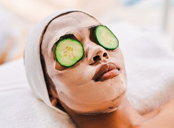 girl getting a facial with cucumber over eyes