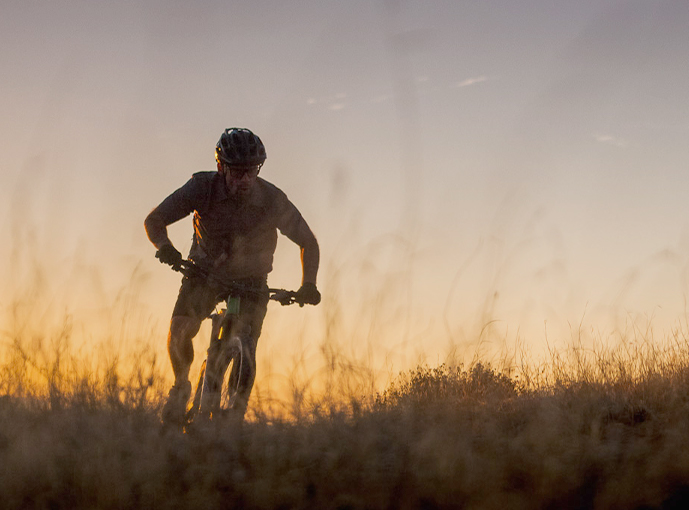 person biking in the grassy terrain