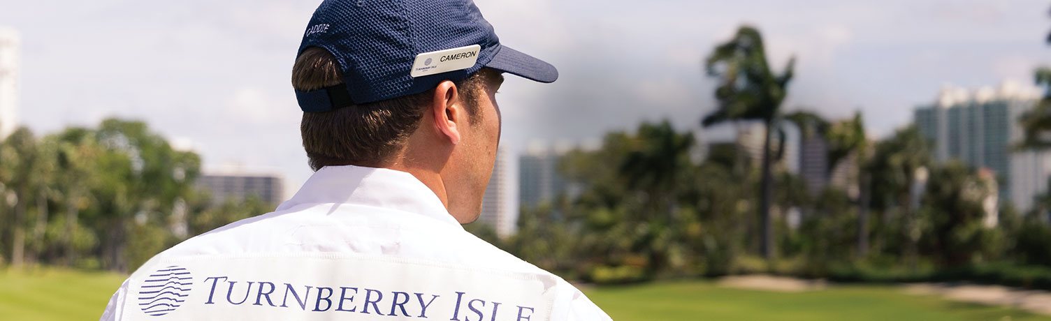 Golf course surrounded by lake & palm trees
