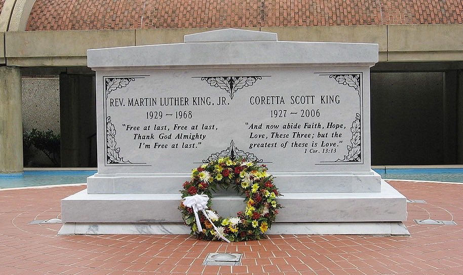 A tombstone with a flower wreath in front 