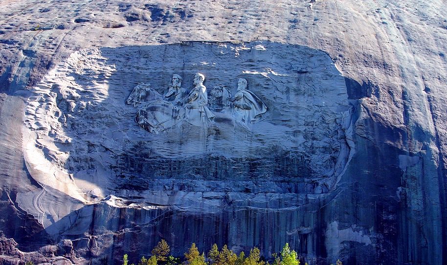 Carving of men riding horses in a stone Mountain