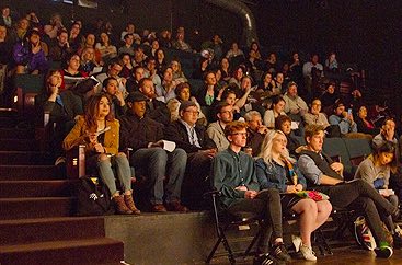 People sitting in a dark auditorium taking notes at Atlanta Film Fest