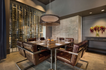 Dark wood table and leather chairs in a restaurant next to the wine cellar