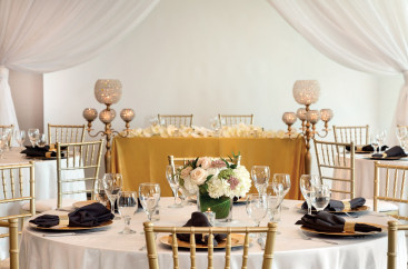 Tables set with white tablecloths and floral arrangements for an elegant event