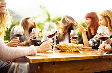 A group of friends sitting at a table drinking wine 