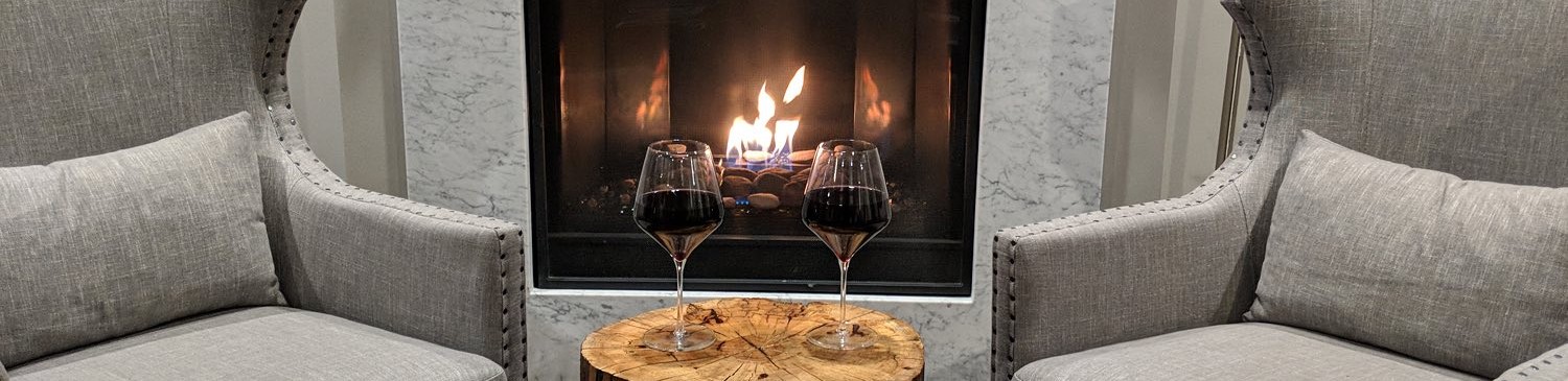 wine glasses in front of a fire with a brown table