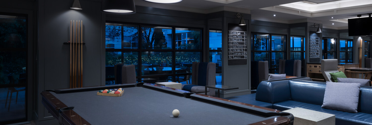 Billiard table with pool sticks on wall