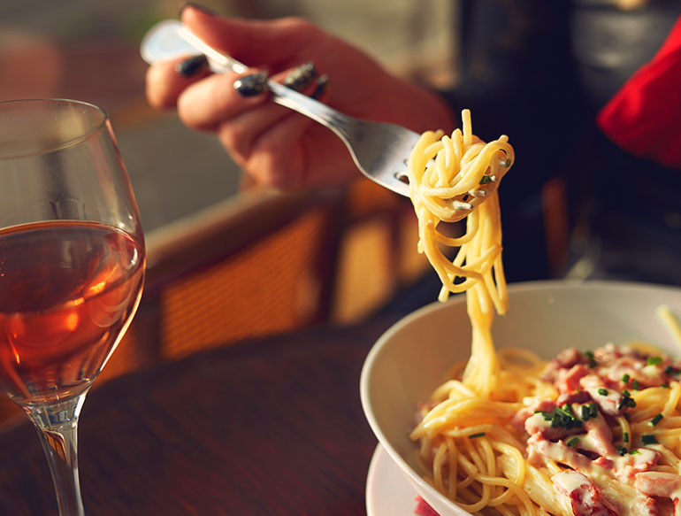 woman enjoying a glass of wine and fresh pasta at barrique