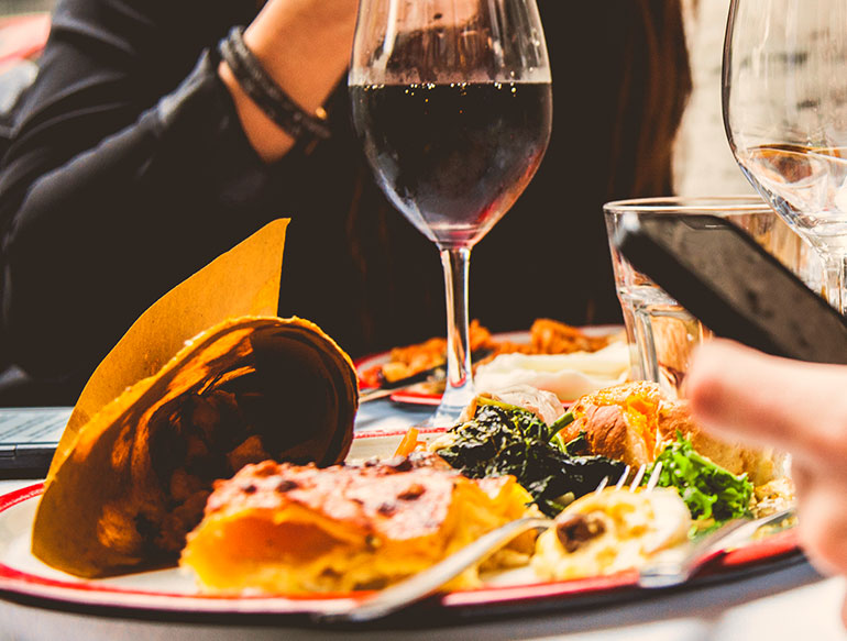 people enjoying glass of red wine and fresh food at rose cafe