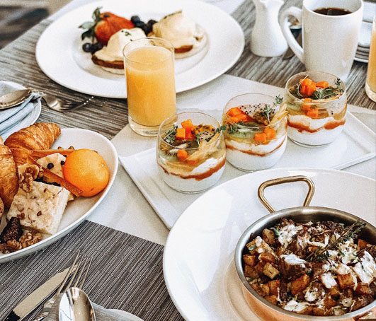 brunch at vistal with white plates with parfaits and potatoes
