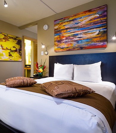 large room with a nice bed and art