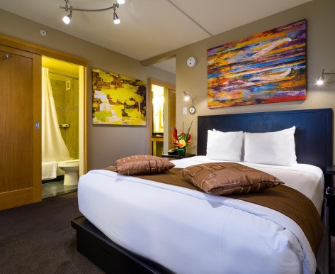 a colorful guestroom with artwork above the bed