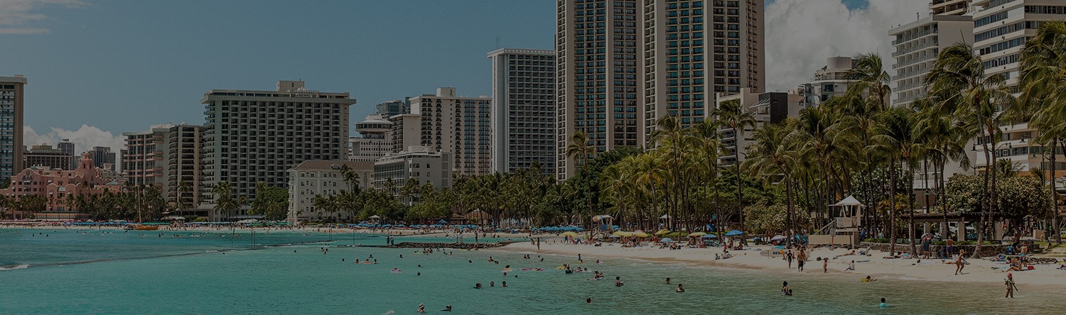 people at the beach with waikiki buildings in the background