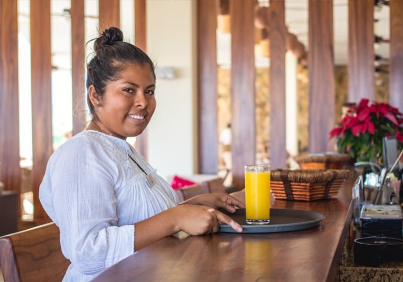 vivo resorts staff member holding a tray with a glass of orange juice