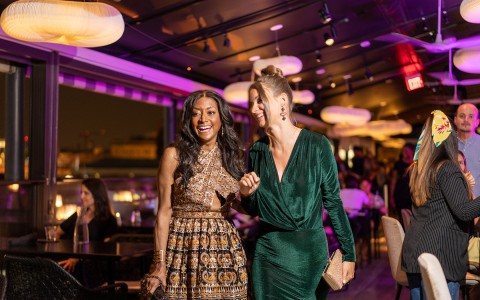 2 women dressed up laughing and walking