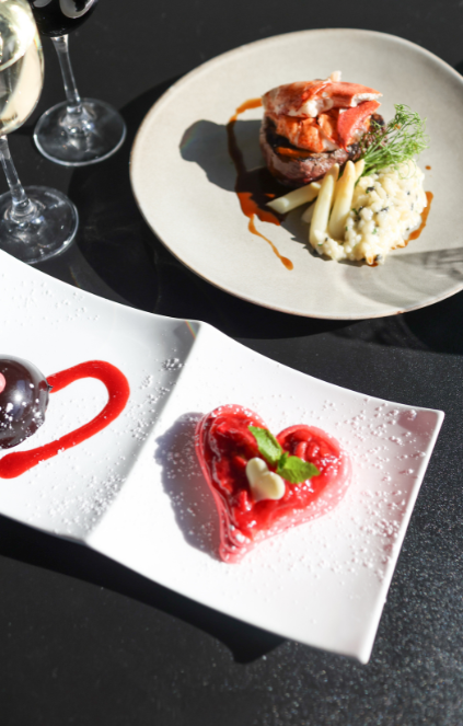 land and sea dish with a heart shaped dessert next to it