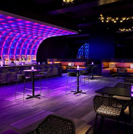 interior of sky room with colorful lights, a bar, and seating area