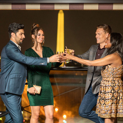 2 couples talking at bar holding cocktails