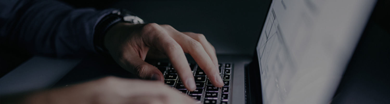man's hands typing on his laptop
