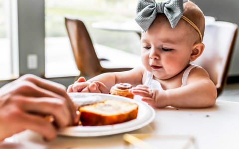 cute baby looking at her appetizer 