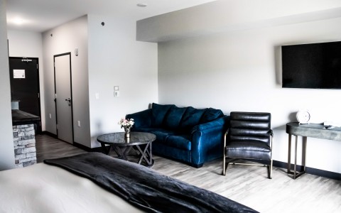 view the corner hotel room with features as a comfy sofa, stylish chair and a tv on the wall