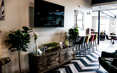 View of a stylish sitting area of property with features as tv on the wall and colorful chairs 