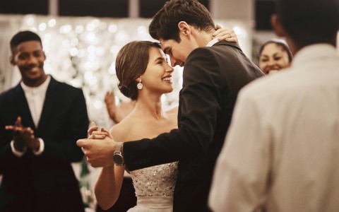 Well dressed couple dancing and smiling looking at each other
