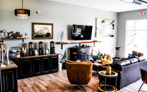 Modish sitting room with features as big tv on the wall, comfy sofa and big armchair