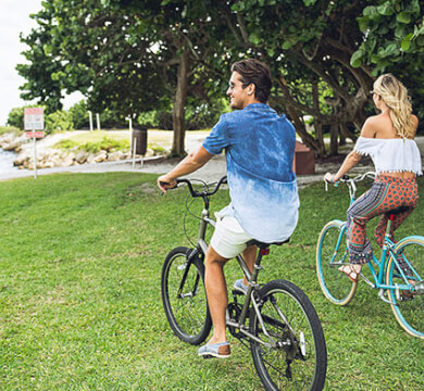Couple riding bikes on grass