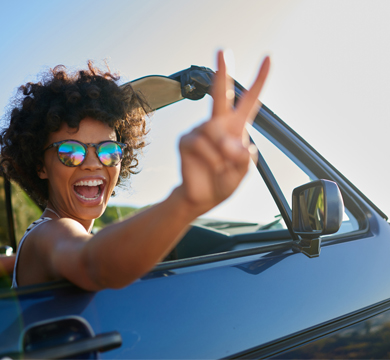 girl with sunglasses driving in convertible