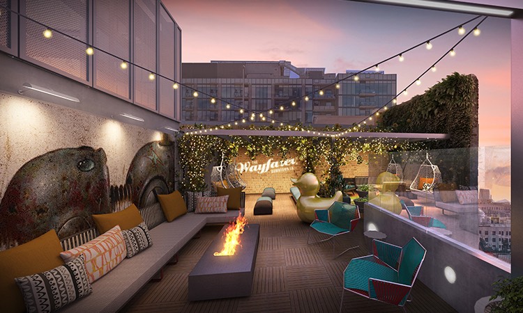modern fire pit on an outdoor lounge area with string lights at night