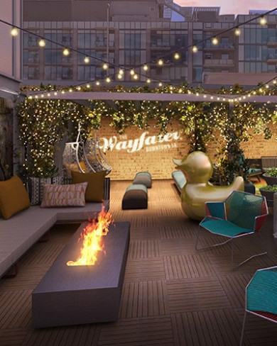 a modern fire pit on an an outdoor lounge area with string lights