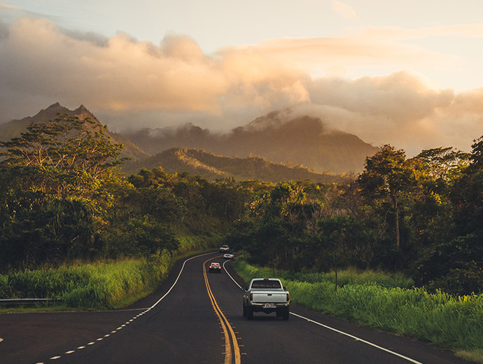 view of a road with cars and the hawaiian landscape