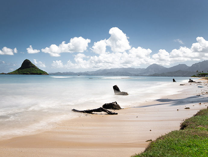 a beautiful beach with the hawaiian mountains in the background 