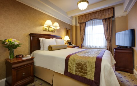 hotel room with king bed and throw blanket