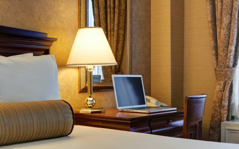 hotel room with work desk and laptop on top of it