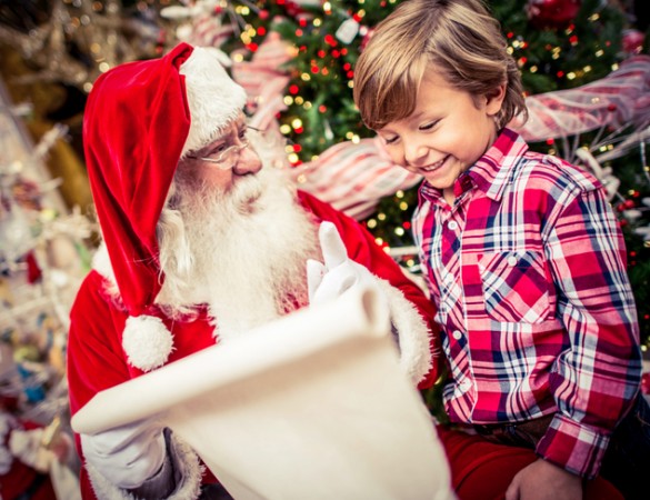 kid with santa reading a christmas list