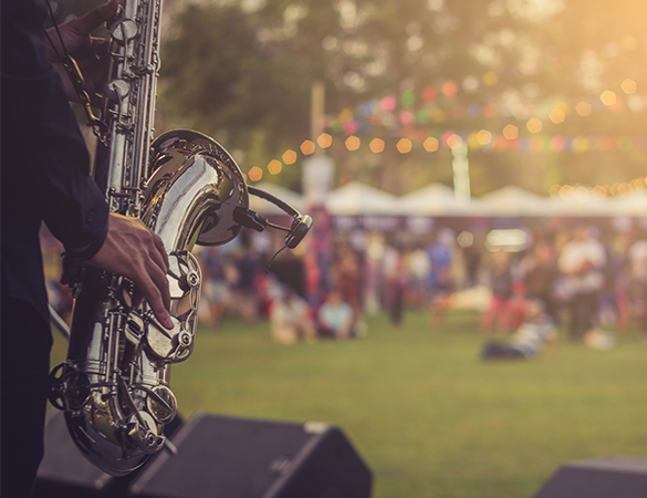a man playing saxophone in a park festival