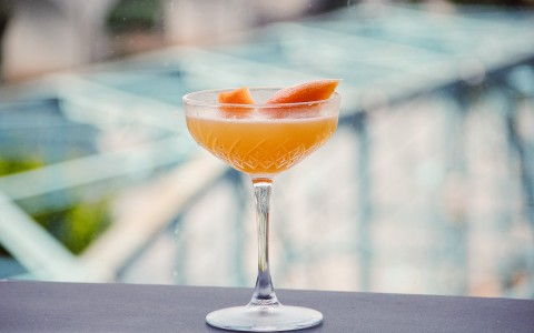 champagne flute with orange drink and garnish