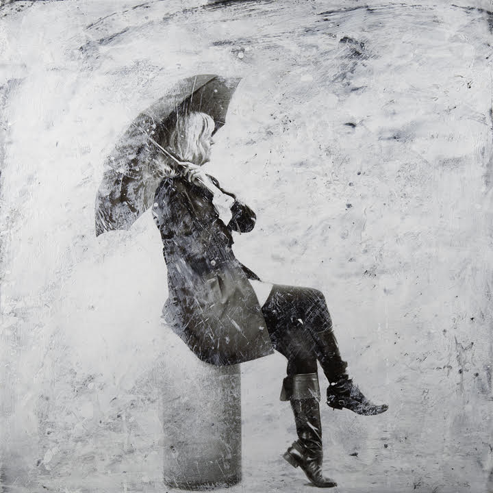 side of a woman sitting with an umbrella in her hand