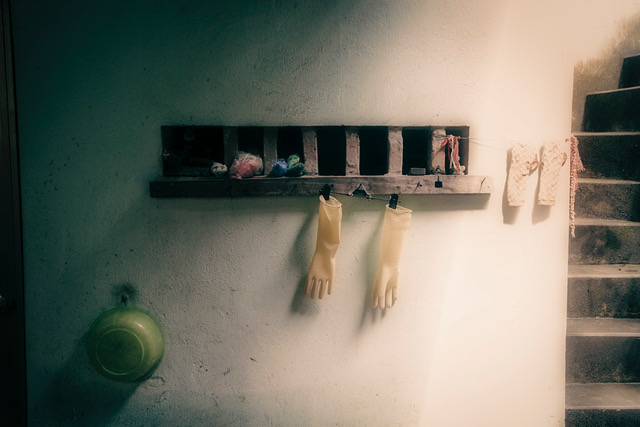 view of small shelve on the wall hanging yellow gloves