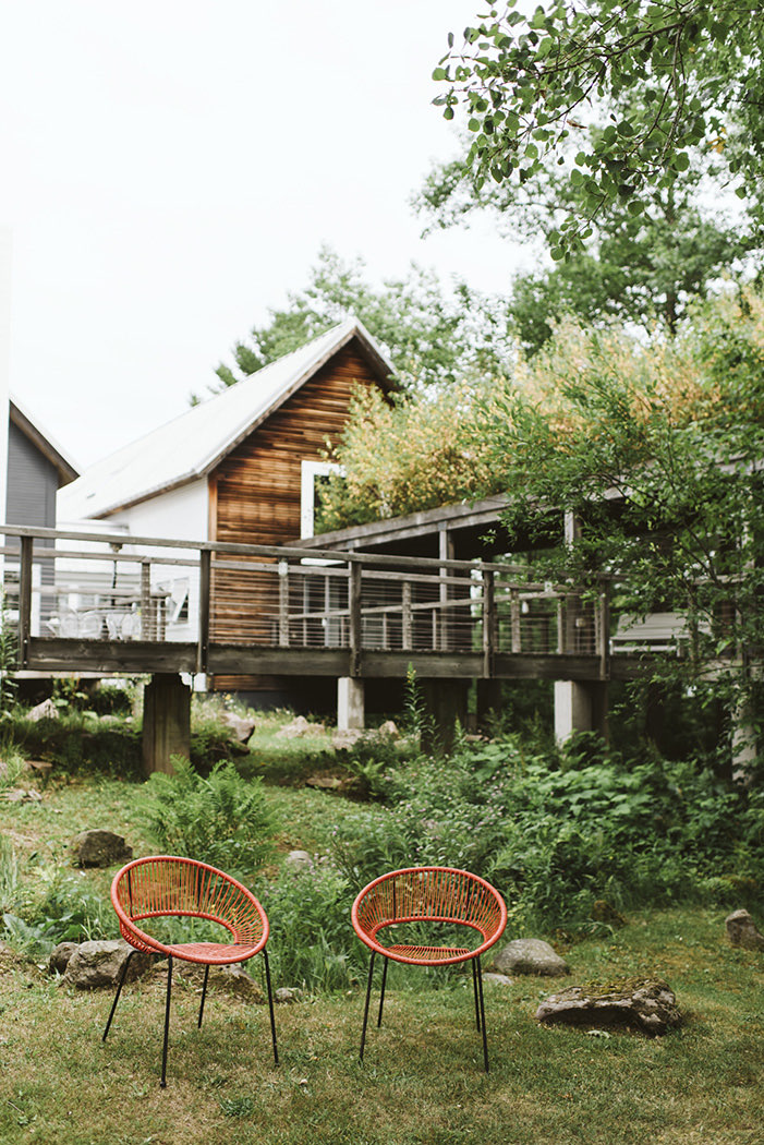 view of cute tree house and two stylish red chairs 