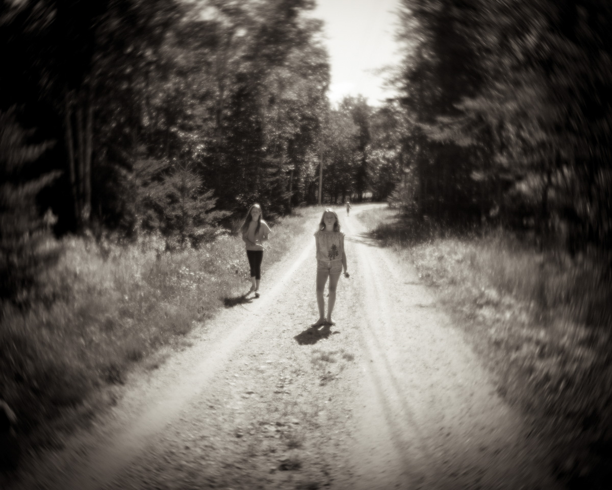 black and white blurry image of two girls walking in the nature 