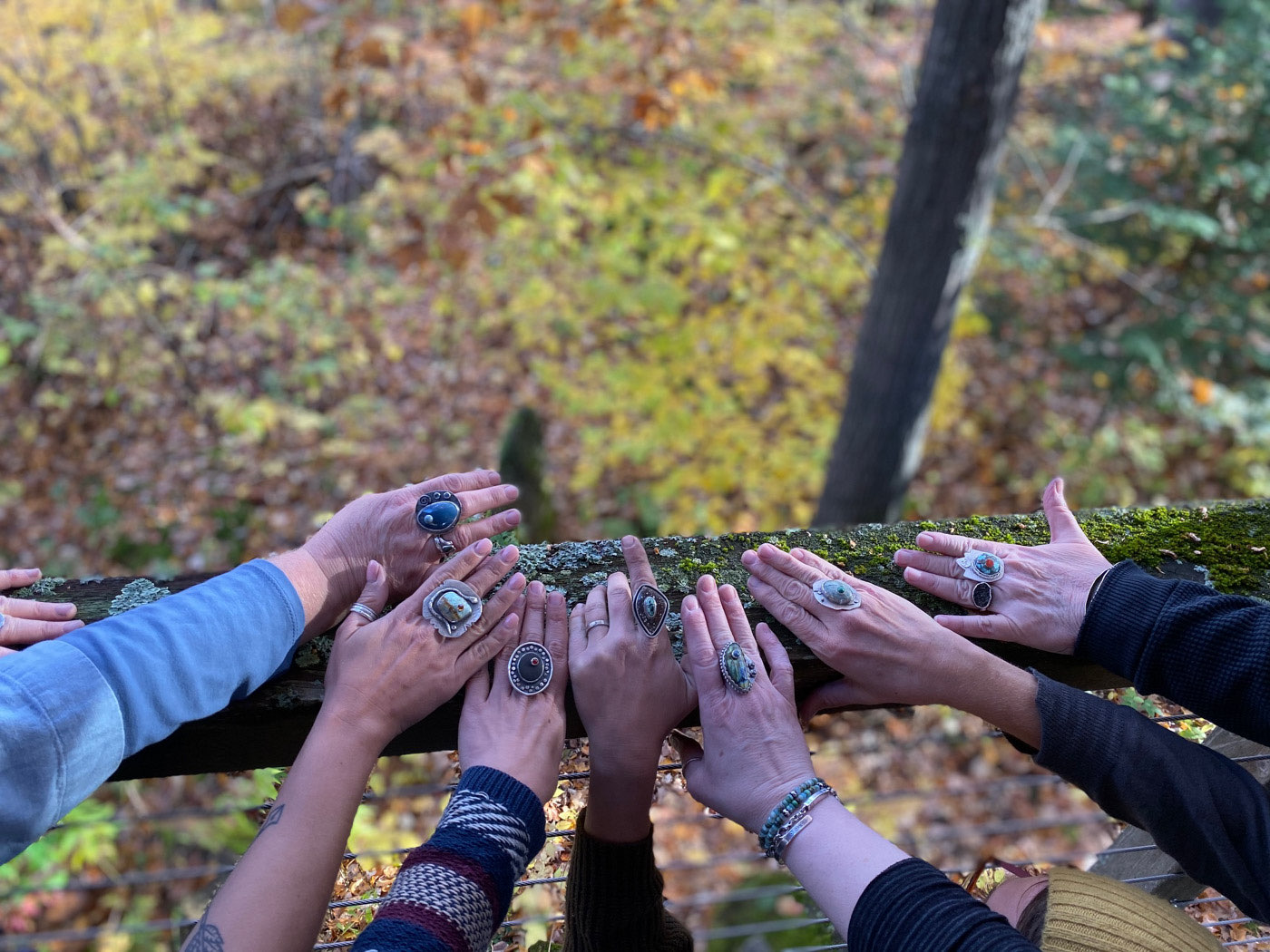 Top view of a bunch of female hands wearing a big ring outdoors