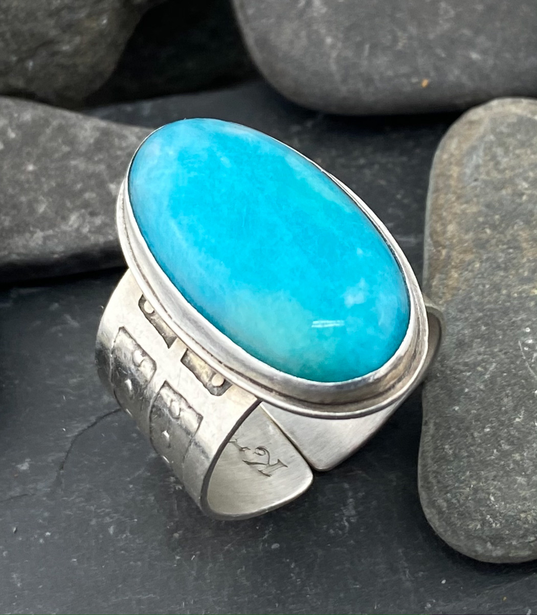Closeup of a metal ring with a blue stone on it