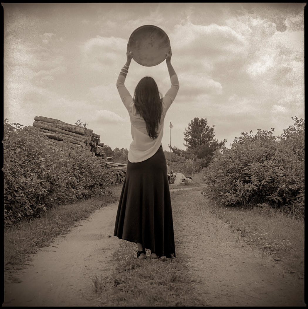 dark image of a back of a woman carrying a medium size bowl 